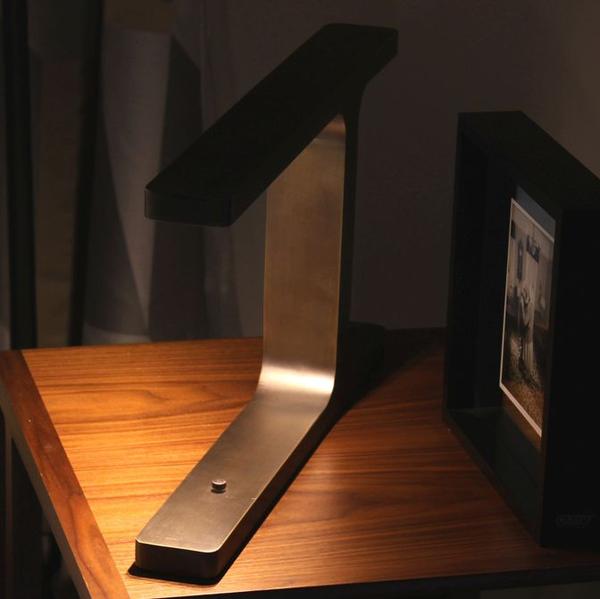 Narrow architectural table light in satin bronze with directional LED illumination