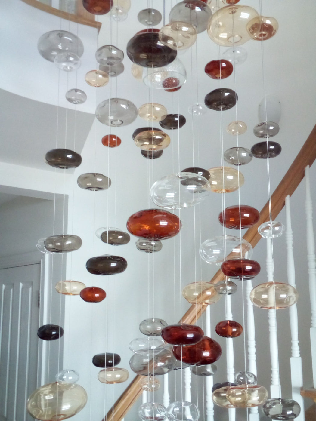 20 feet tall bespoke stairwell chandelier with colored glass bubbles