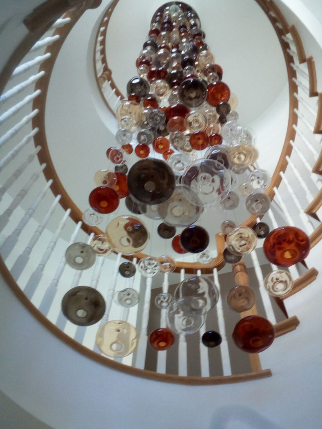 20 feet tall bespoke stairwell chandelier with colored glass bubbles