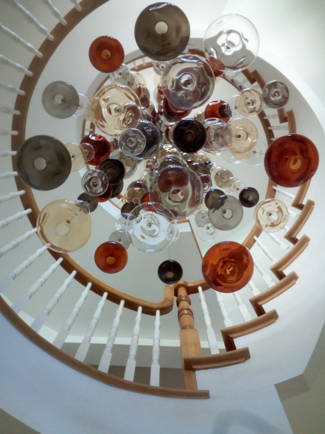 20 feet tall bespoke stairwell chandelier with colored glass bubbles