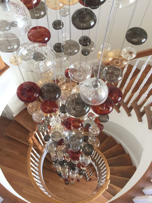 20 feet tall bespoke stairwell chandelier with colored glass bubbles